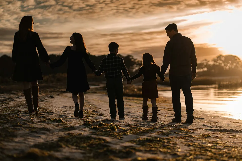 Family walking on the beach at sunset